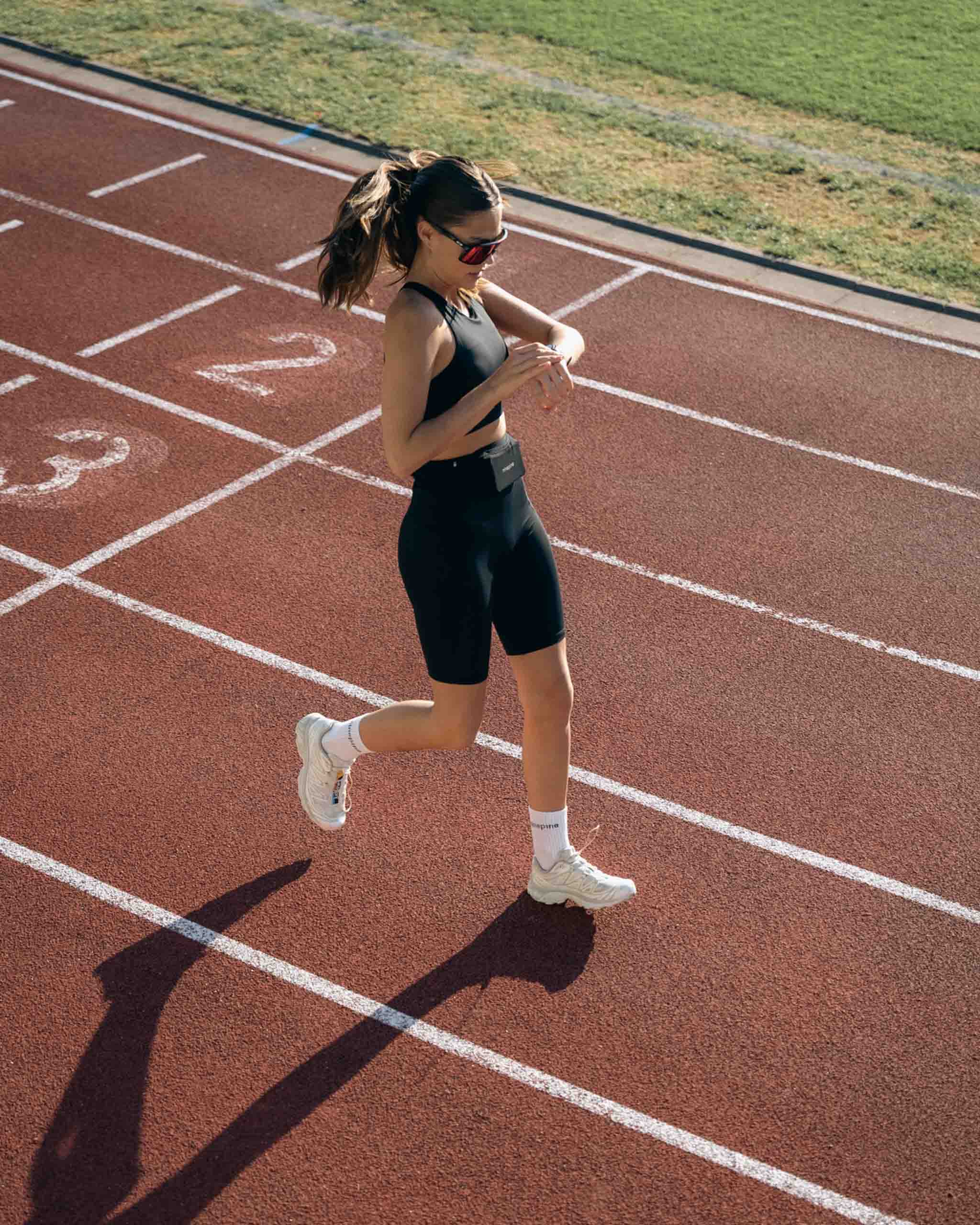 Girl running on track with ninepine outfit