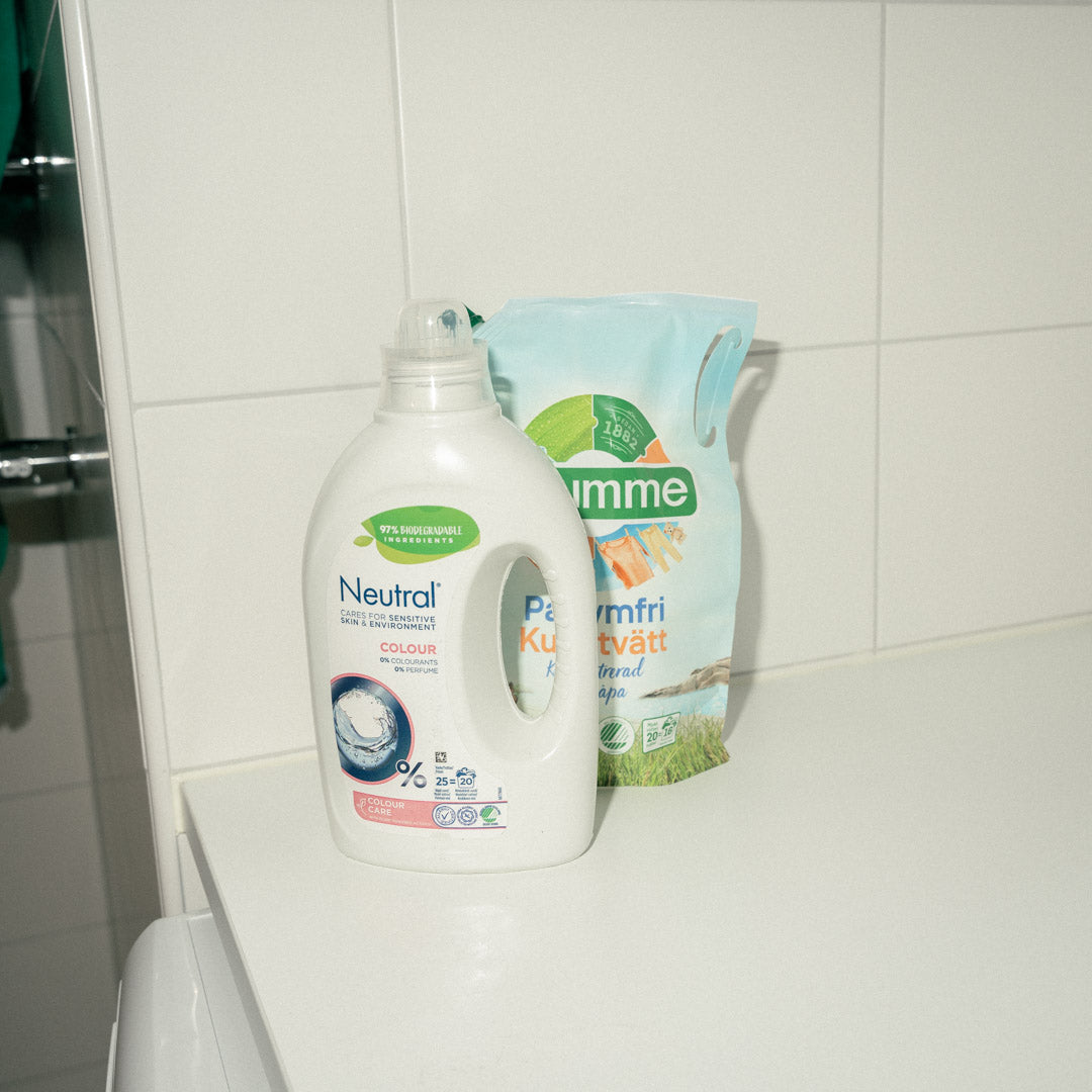 Two bottles of washing detergent liquid on top of a bench top