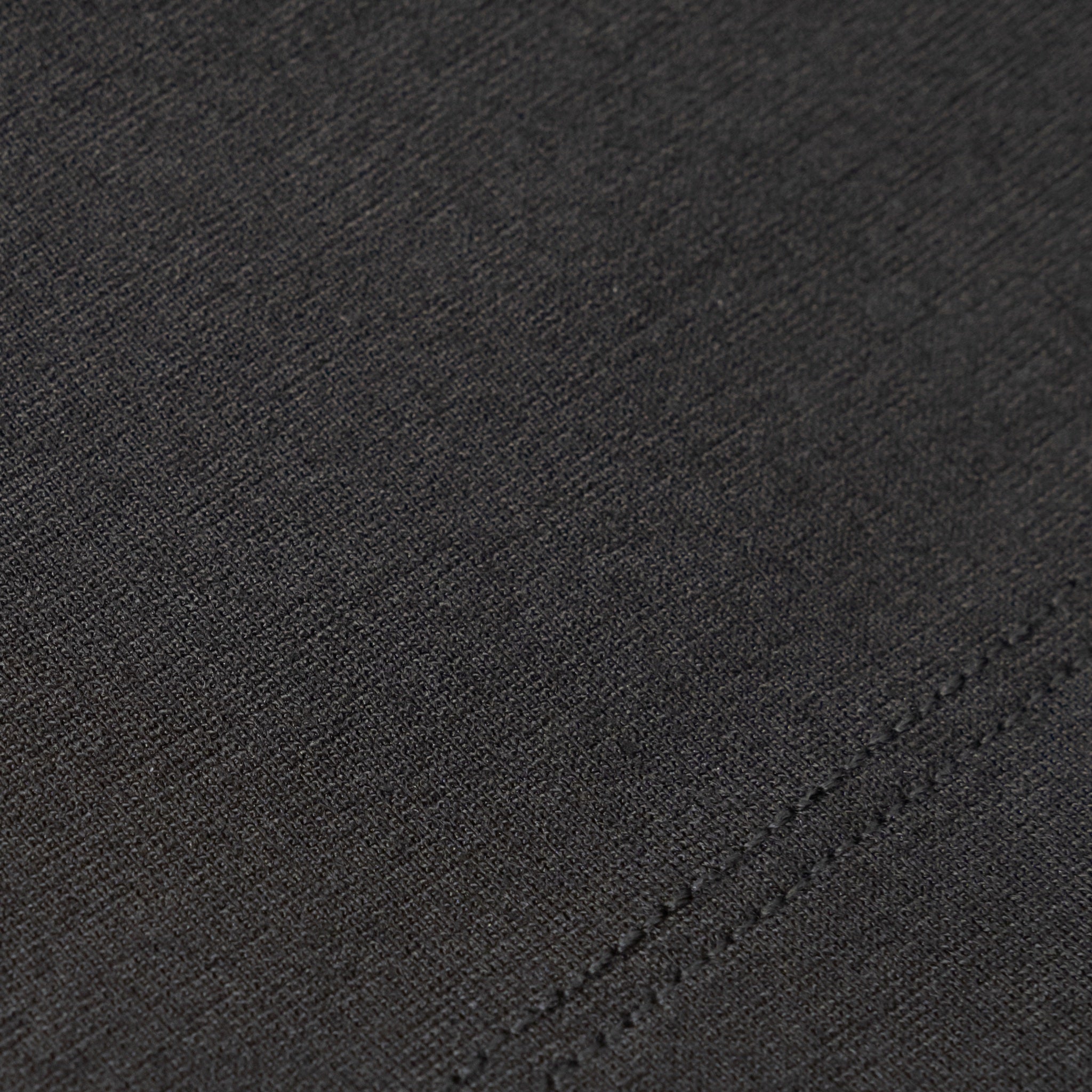 Close-up of black Ninepine Ponte fabric with stitching detail.